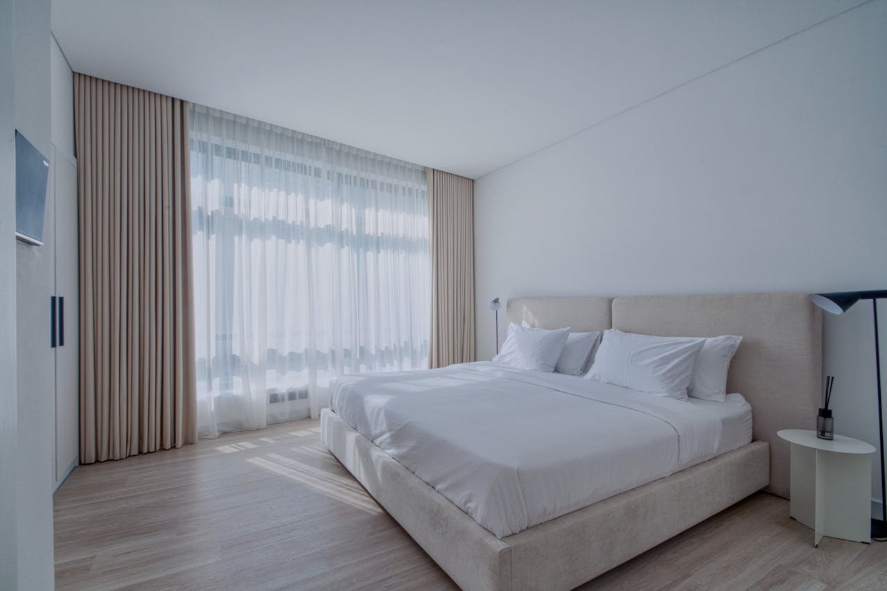 A serene and modern bedroom interior with elegant neutral tones and natural light.